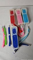 Four aftermarket Wii controllers with sleeves, plus extra wrist straps