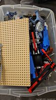Bin with tan baseplate covering assorted LEGO parts