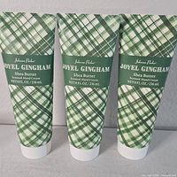 Front view of three identical Johnson Parker Joyel Gingham Shea Butter hand cream tubes