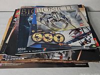 Stack of assorted LEGO and Mega Bloks manuals, Bionicle 8594 visible on top