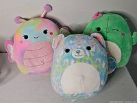 Three Squishmallows plush toys side by side