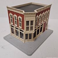 Front and side view of model building showing brick facade and storefront
