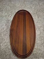 Top view of teak oval tray showing grain and grooved rim