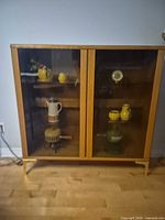 Front view of wood veneer display cabinet with glass doors