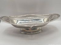 Side view showing pierced sides, ornate rim, foot