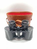 Binoculars front view with open leather case showing red interior