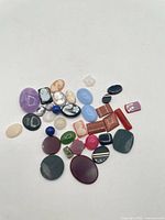 Group view of all 36 cabochons, cameos and beads on white background