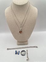 Group shot of all six sterling jewelry pieces on bust and surface
