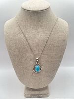 Full view of necklace on display bust showing chain length and pendant size