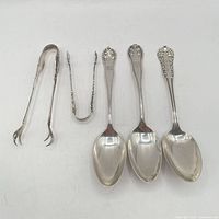 Group of three teaspoons and two sugar tongs