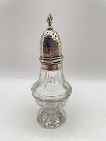 Full view of sugar caster showing silver top and glass body