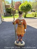 Front view of full Beefeater statue holding metal staff