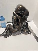 Full view of sculpture beside water bottle for scale
