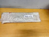 bundle of three acrylic shelves wrapped in plastic on tabletop