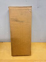 Sealed brown shipping box containing plant stand