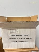 Closed carton showing printed specs: 4 × 6 in., die cut, 1 in. core, 410/roll, 12 rolls/case