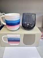 Mug and wine glass on top of original box