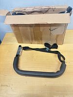 Opened box showing one tubular steel hook with attached strap