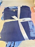 Entire pajama set folded and tied with ribbon, showing top and pants