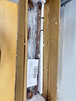 Fixture parts wrapped in plastic and foam inside original cardboard box