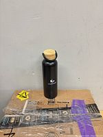 Black stainless water bottle with bamboo lid and Chartwell logo