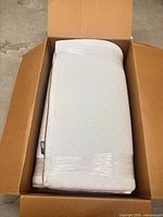 Rolled mattress topper inside open box