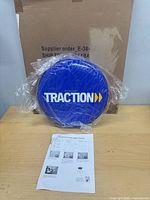 Blue vinyl seat cushion with "TRACTION" logo, instruction sheet, shipping box