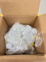 Open shipping box showing sealed packs of translucent bottles inside