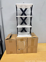 Three sealed cardboard boxes with assembled sample rack beside