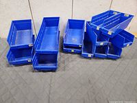All 13 blue plastic bins stacked and grouped