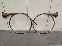 Both brass hunting horns side by side showing identical design