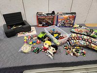 entire lot layout showing K'NEX boxes, toolbox, bin of toys, plush dolls, play mat