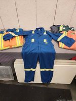Assorted coveralls laid out and folded on table