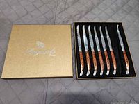 Closed presentation box and open tray showing seven knives