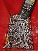 Overview of red bin filled with sockets, ratchet, screwdriver, socket rail