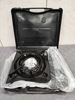 Stove inside open carry case, factory plastic wrap visible