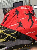 Quilt draped open showing red player silhouette panel and black hoop/net panel