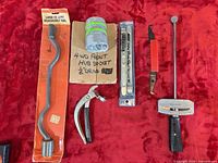 All six automotive tools laid out on red surface