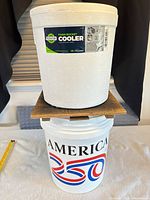 Foam cooler stacked on plastic pail, showing label on cooler