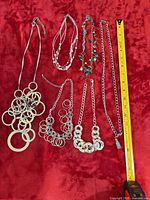 All seven jewellery pieces laid out with measuring tape for scale