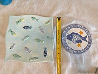 Square plate and round trivet top view with ruler for size reference