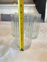Clear ribbed glass vase with tape measure indicating height ~9.5 in