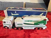 Side view of Hess truck with space shuttle attached and box in background