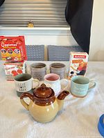 Group shot of all items including teapot, mugs, butter crocks, egg cooker boxes, fry holder box
