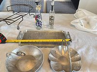 Overall lot view showing metal tray, decorative bowls, casserole stand, oil bottles