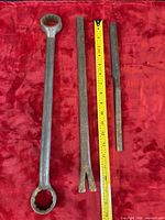 Three long hand tools with measuring tape for scale
