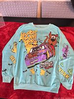 Front view of sweatshirt showing main cartoon graphic and sleeve text
