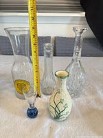 Front view of all five vases with measuring tape for scale