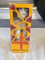 Front of boxed item showing doll inside packaging