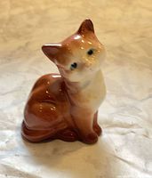 Front view of small glazed porcelain cat figurine